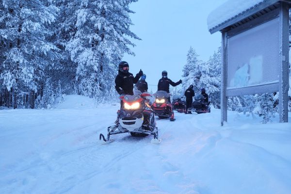 Moottorikelkat jonossa moottorikelkkasafarilla talvisissa maisemissa.